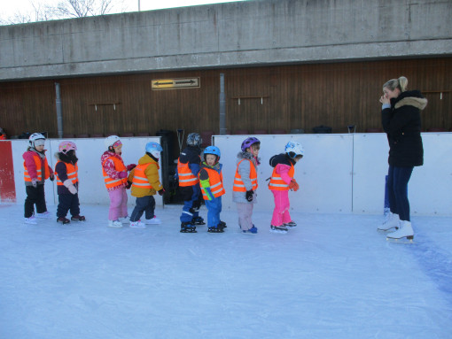 Kinder und Pädagogin beim Eislaufen