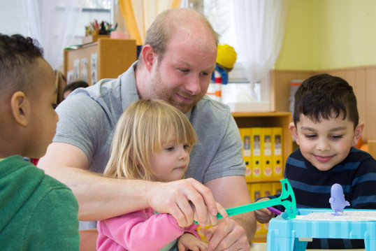 Kinder spielen mit Pädagogen 