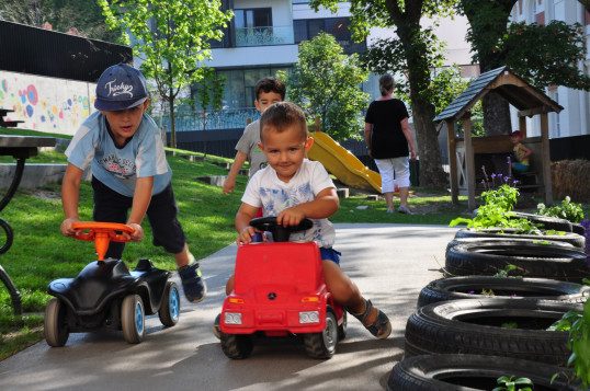Kinder fahren mit Bobbycars im Freien 
