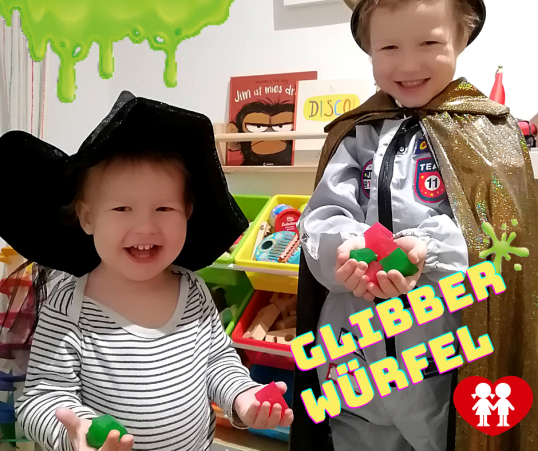 Kinder lachen und halten Glibberwürfel in Händen 