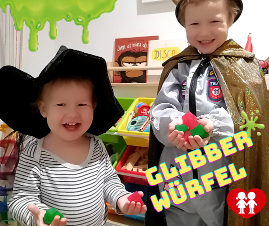 Kinder lachen und halten Glibberwürfel in Händen