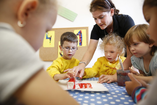 Pädagogin unterstützt Kinder beim Experimentieren