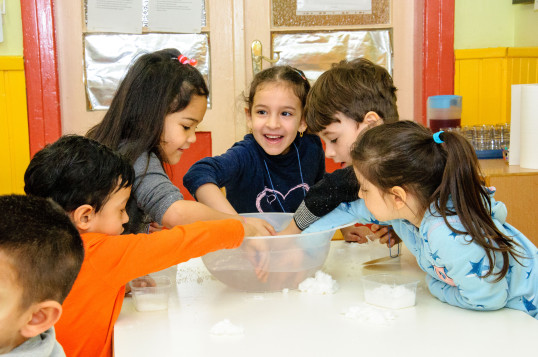 Kinder greifen bei Experiment in eine Schüssel