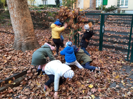 Kinder bewegen sich im Herbstlaub