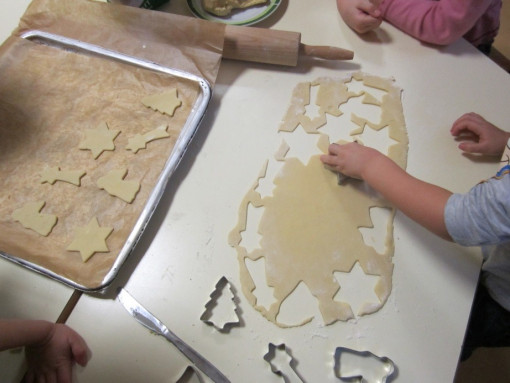 Kinder stechen Weihnachtskekse aus