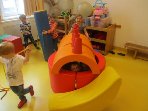 Kinder Bauen ein Haus aus großen Bauelementen im Bewegungsraum