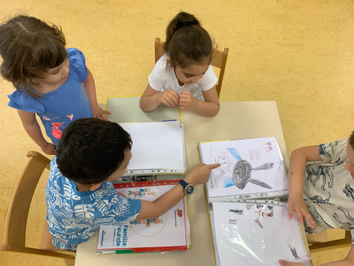 Vier Kinder beschäftigen sich mit ihrer Portfoliomappe
