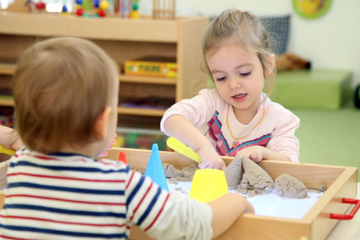 Kind spielt mit Sand im Kindergarten