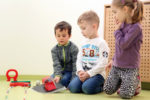 Drei Kinder gestalten gemeinsam eine kleine Maschine