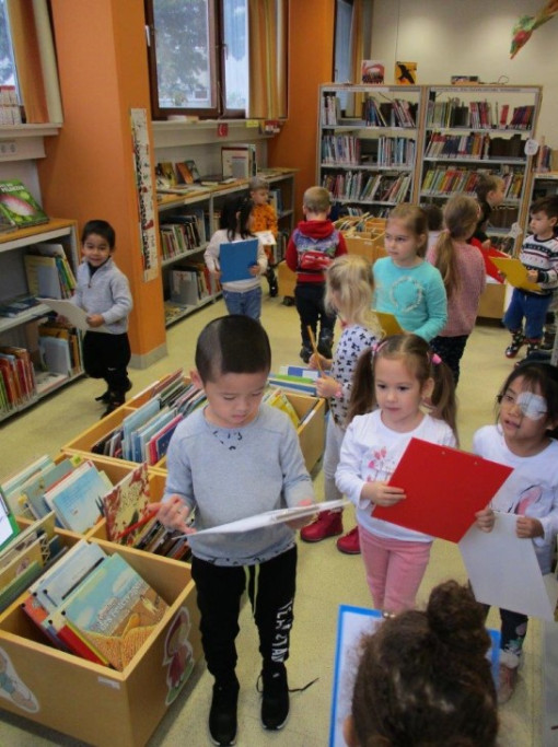 Kinder erfüllen eine Aufgabe in in einer Bücherrei