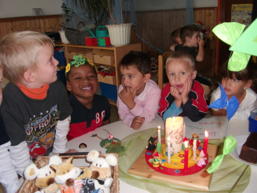 Geburstagsfeier: Kinder fsitzen am Tisch und feiern mit Torte 