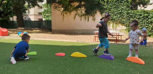 Kinder balancieren auf bunten Plattformen im Garten