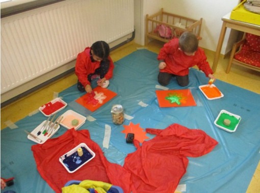 Zwei Kinder gestalten kreative Bilder mit verschiedenen Farben