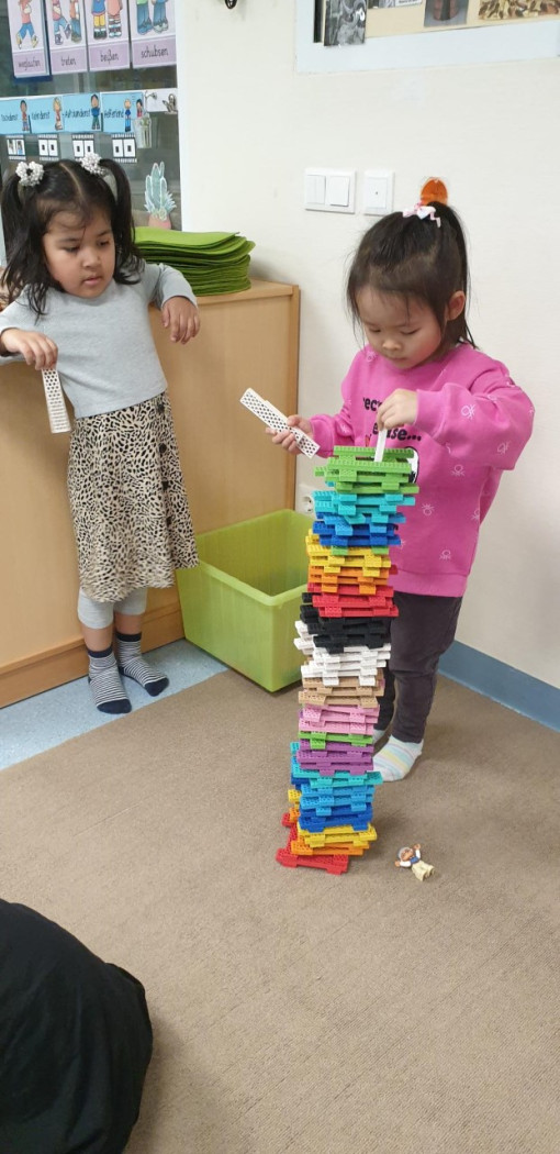 Ein Kind baut mit Konstruktionsbausteinen einen Turm