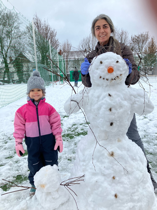Ein Kind hat gemeinsam mit der Pädagogin einen Schneemann gebaut