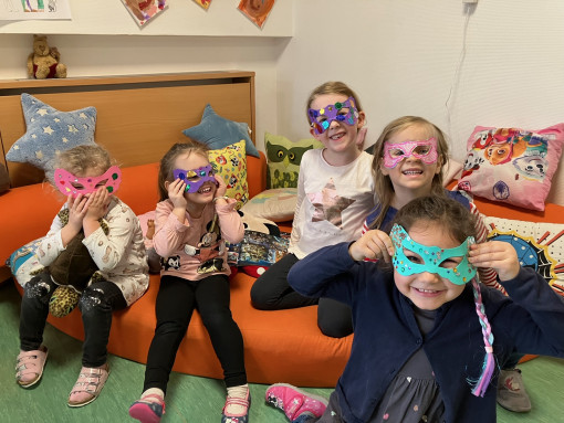 Kinder sitzen mit Masken im Lesebereich