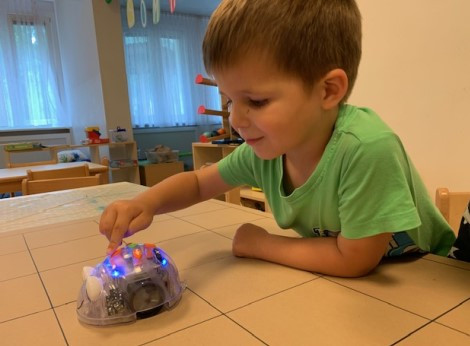 Ein Junge spielt glücklich mit einer mechanischen Spielzeugmaus