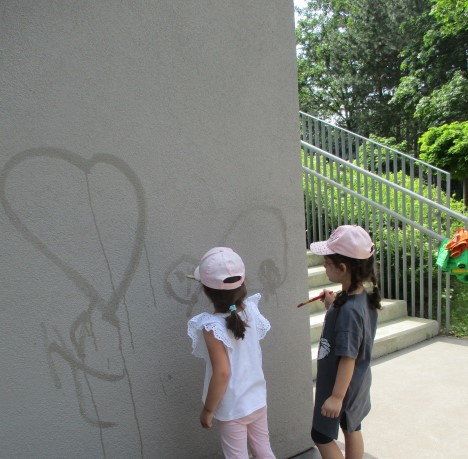 Zwei Mädchen bemalen eine Wand