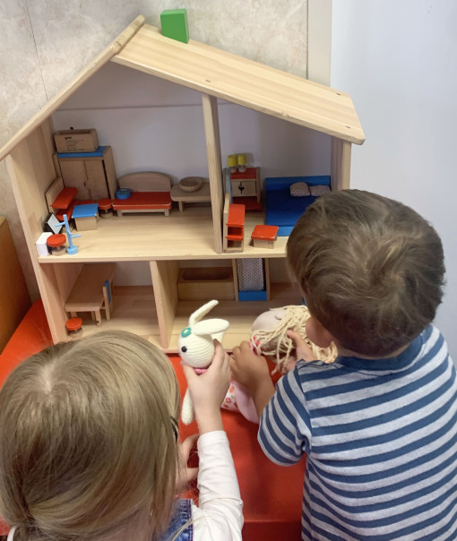 Zwei Kinder beim Puppenhaus