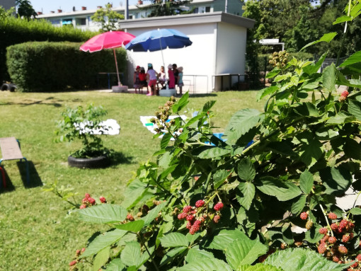 Kinder rasten unter einem Sonnenschirm an einem heißen Sommertag im Garten