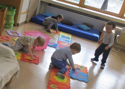 Kinder spielen mit Puzzle-Teppich