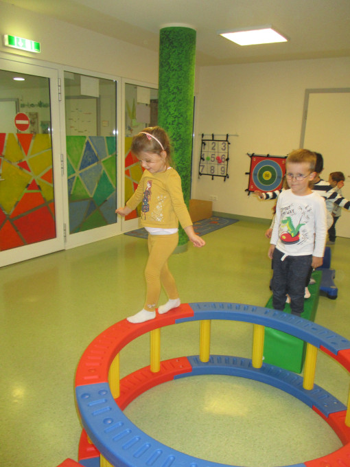 Kinder balanzieren konzentriert auf einem Ring im Bewegungsraum