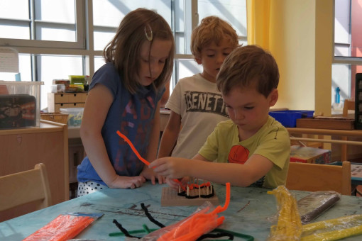 Drei Kinder arbeiten kreativ mit bunten Pfeifenpuzern