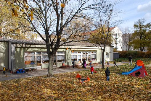 Kinder spielen miteinander im Herbstlaub des großen Gartens 
