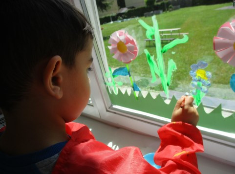 Kind bemalt Fenster mit Blumen