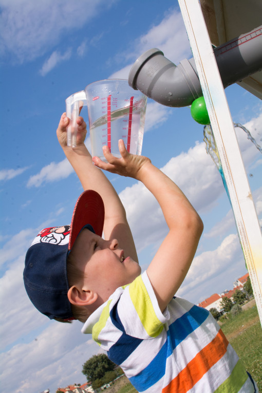 Bub leert Wasser in Regenrinne