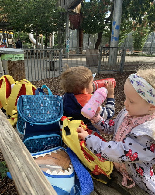 Kinder packen ihre Jause beim Ausflug im Park aus