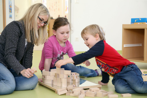 Pädagogin baut mit Kindern Holzturm 