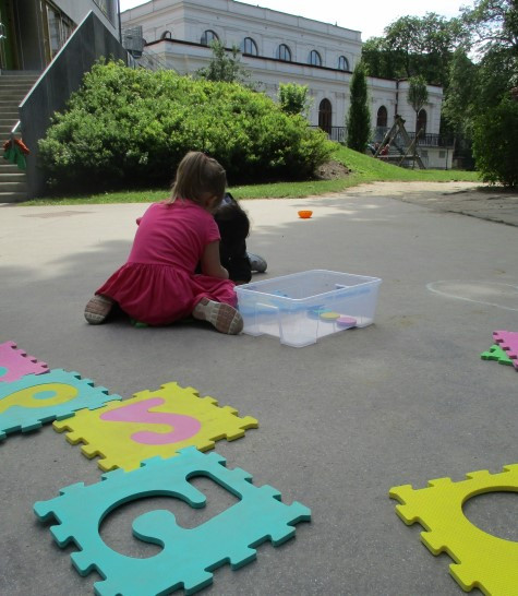 Kinder spielen im Garten mit Moosgummi Zahlen