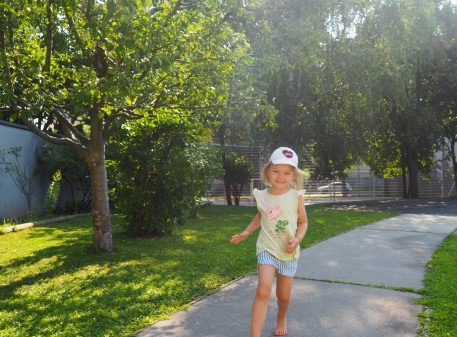 Ein Mädchen läuft strahlend durch den Garten