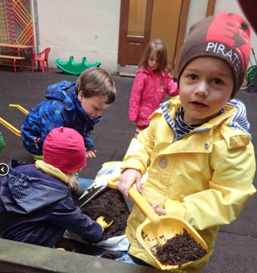 Kinder schaufeln Erde aus Erdsack 