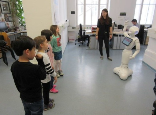 Pädagogin zeigt Kindern einen Roboter