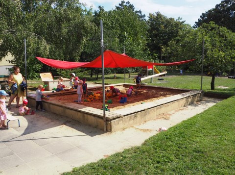 Kinder spielen im großen Sandkasten