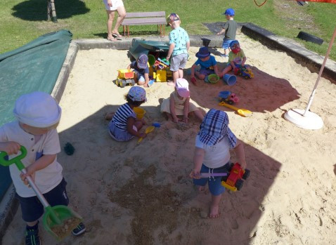 Kinder beim Spielen in der Sandkiste im Sommer