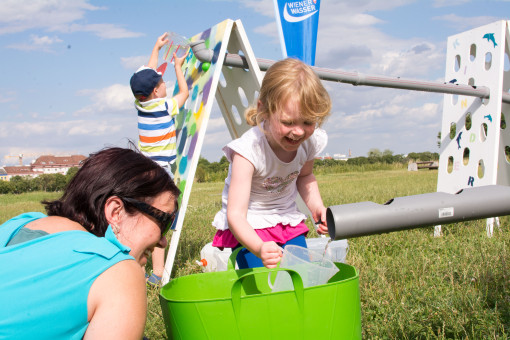 Kind und Frau pritscheln mit Wasser