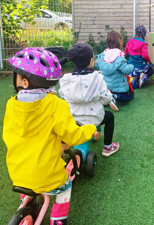 Kinder sitzen auf Fahrzeugen im Garten