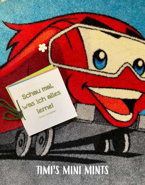 Timitaurus, das Maskottchen der ÖBB für die Timi´s Mini Mints Kindergärten trägt ein Buch mit dem Titel "Schau mal, was ich alles lerne"